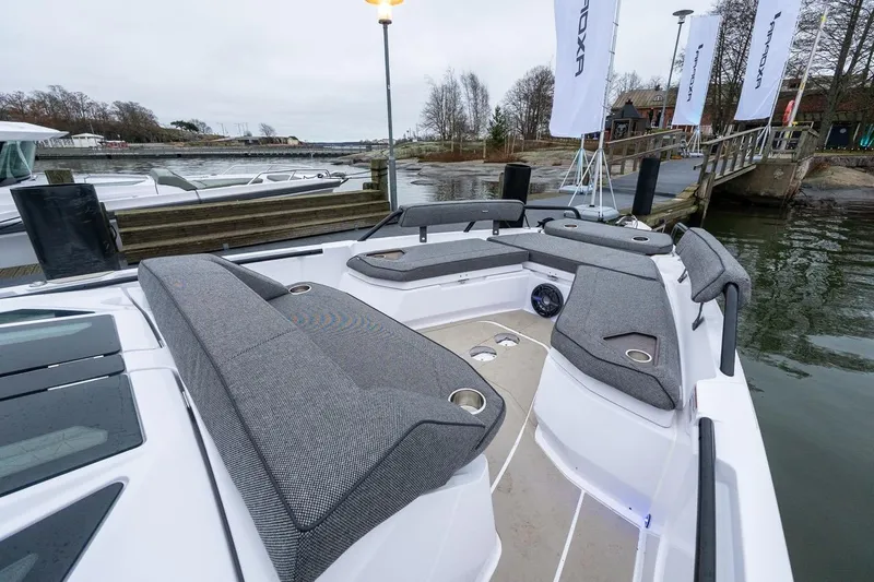 Slide: The Image of 2027 Axopar 38 Cross Cabin boat with spacious seating and modern design at a dock. - 24