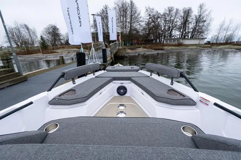 Slide: The Image of 2027 Axopar 38 Cross Cabin boat with spacious seating at a dockside location. - 25