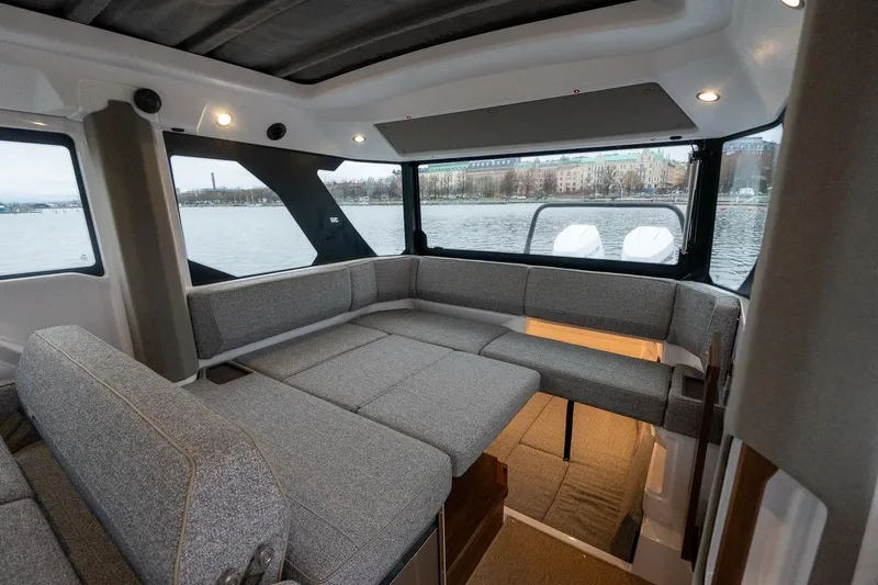 Slide: The Image of Interior of 2027 Axopar 38 Cross Cabin with gray seating and panoramic windows. - 30