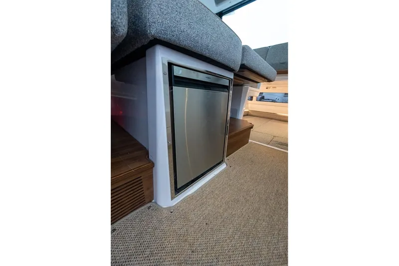 Slide: The Image of Interior view of 2027 Axopar 38 Cross Cabin with compact fridge and seating. - 33
