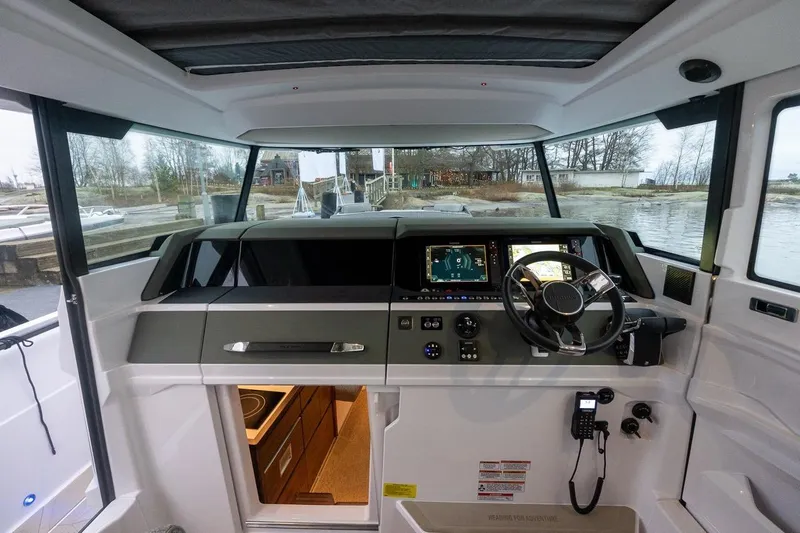 Slide: The Image of 2027 Axopar 38 Cross Cabin interior with modern dashboard and steering wheel. - 36