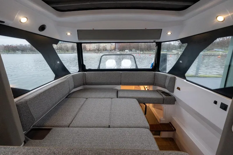 Slide: The Image of 2027 Axopar 38 Cross Cabin interior with panoramic windows and comfortable seating. - 44