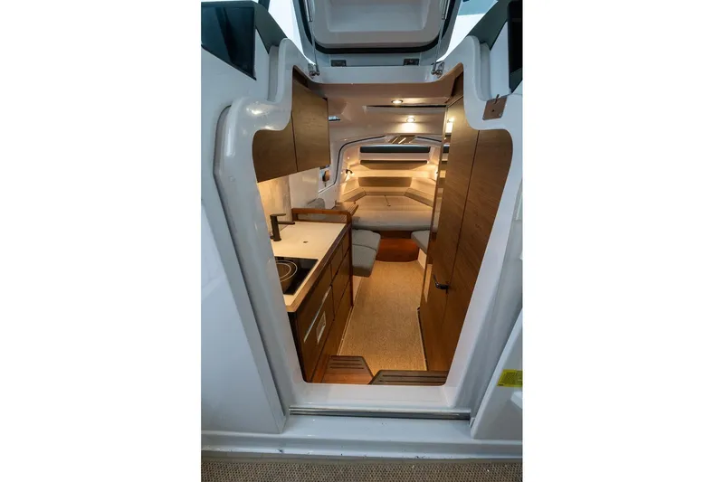 Slide: The Image of Interior view of 2027 Axopar 38 Cross Cabin, featuring modern kitchen and cozy sleeping area. - 45