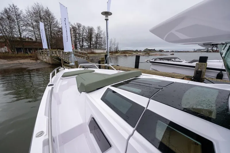 Slide: The Image of 2027 Axopar 38 Cross Cabin boat docked by a wooden pier on a cloudy day. - 79