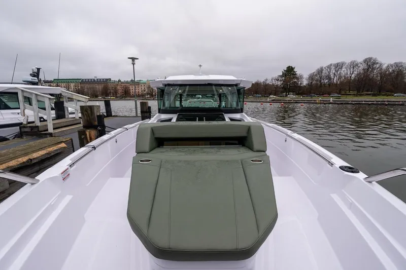 Slide: The Image of 2027 Axopar 38 Cross Cabin boat docked by a calm waterfront. - 82