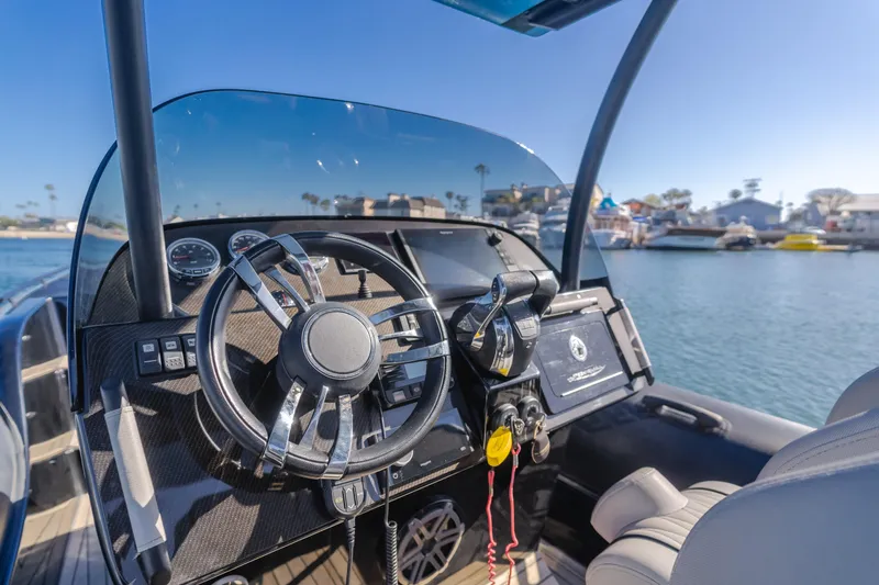 Slide: The Image of 2019 Technohull sea DNA 999 boat dashboard with steering wheel and controls, docked in marina. - 21