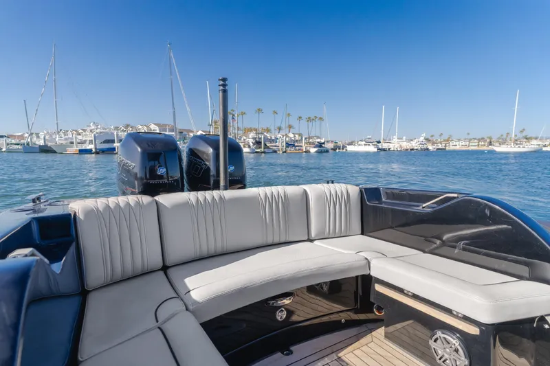 Slide: The Image of 2019 Technohull Sea DNA 999 boat interior with seating, docked in a marina under clear blue skies. - 27