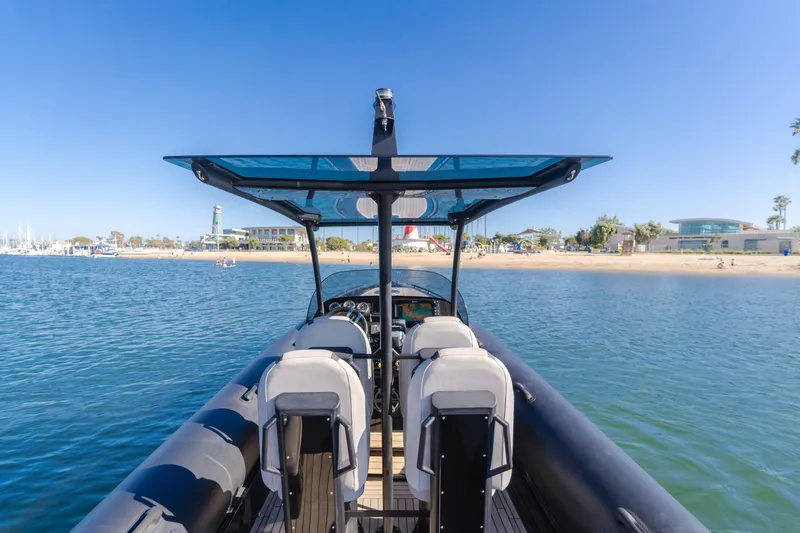 Slide: The Image of 2019 Technohull sea DNA 999 boat on calm water near a sandy beach. - 29
