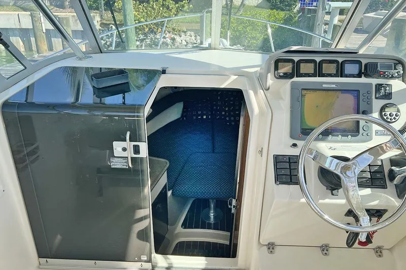 Slide: The Image of 2007 Pursuit OS 285 Offshore boat cockpit with navigation equipment and cabin entrance. - 11