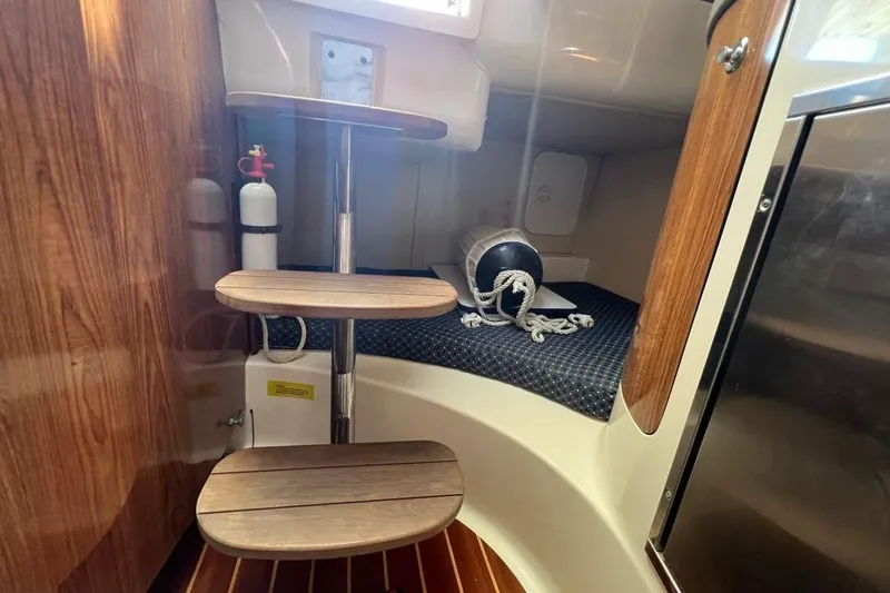 Slide: The Image of 2007 Pursuit OS 285 Offshore cabin interior with wooden steps and nautical equipment. - 12