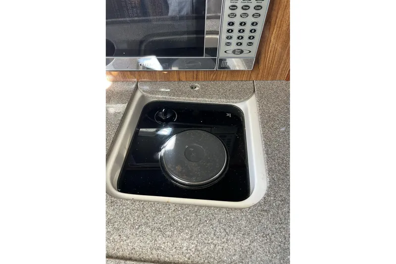 Slide: The Image of 2007 Pursuit OS 285 Offshore kitchen with microwave and stove. - 14