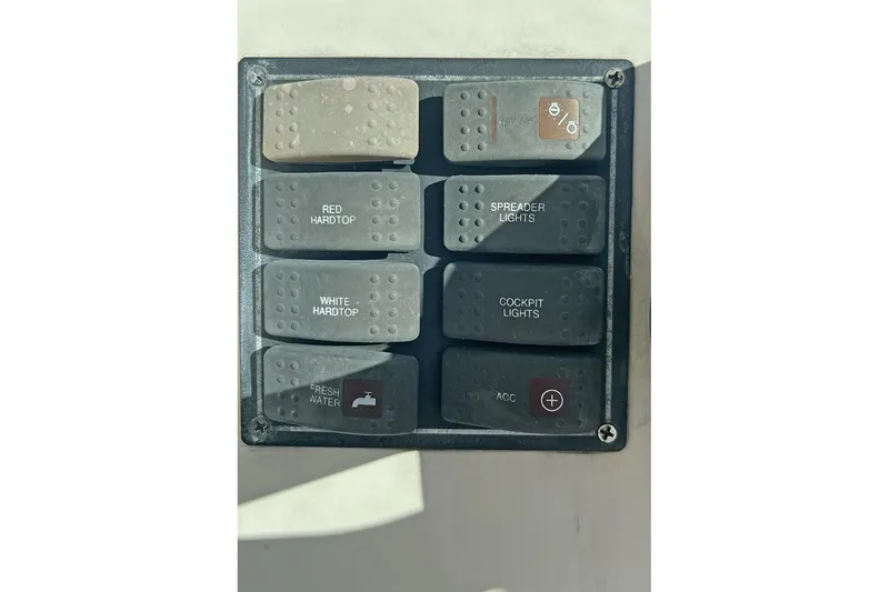 Slide: The Image of Control panel on a 2007 Pursuit OS 285 Offshore boat with labeled switches. - 9