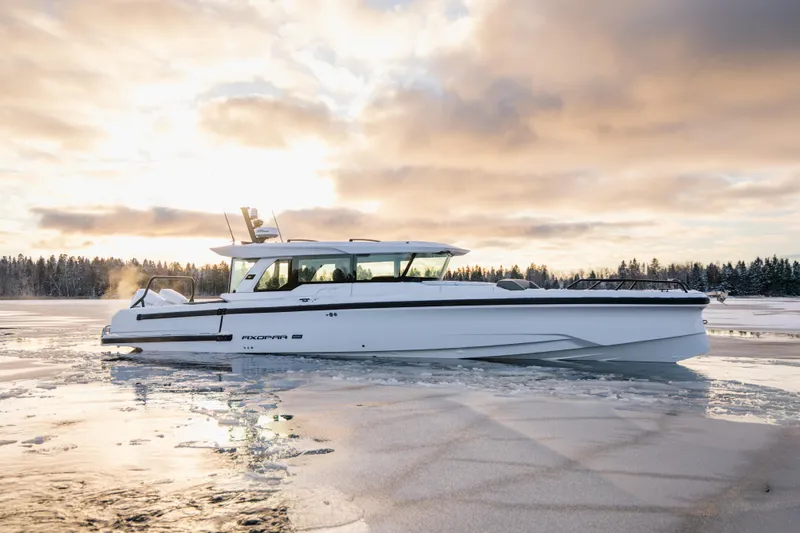 The Image of 2026 Axopar 38 Cross Cabin boat on icy water at sunrise. - 0
