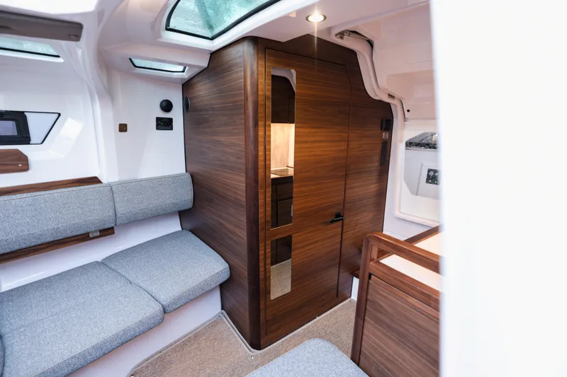 Slide: The Image of Interior of 2026 Axopar 38 Cross Cabin with modern wood finish and gray seating. - 10
