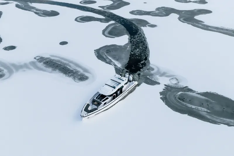 Slide: The Image of 2026 Axopar 38 Cross Cabin navigating through icy waters. - 5