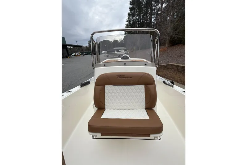 Slide: The Image of 2026 Pioneer 180 Islander boat with brown and white seating, docked outdoors. - 4