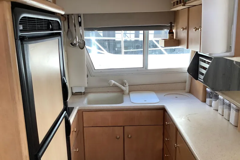 Slide: The Image of Kitchen area of a 1997 Carver 500 Cockpit Motor Yacht with wooden cabinets and appliances. - 11