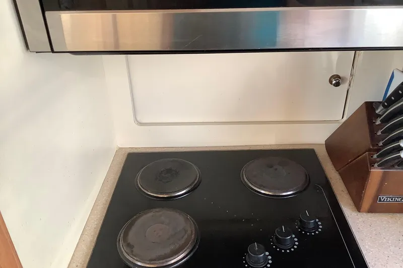 Slide: The Image of 1997 Carver 500 Cockpit Motor Yacht kitchen with electric stove and knife set. - 12