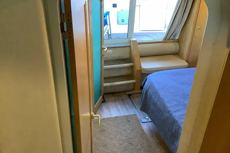 Slide: The Image of 1997 Carver 500 Cockpit Motor Yacht interior with white seating and helm, cityscape view. - 2