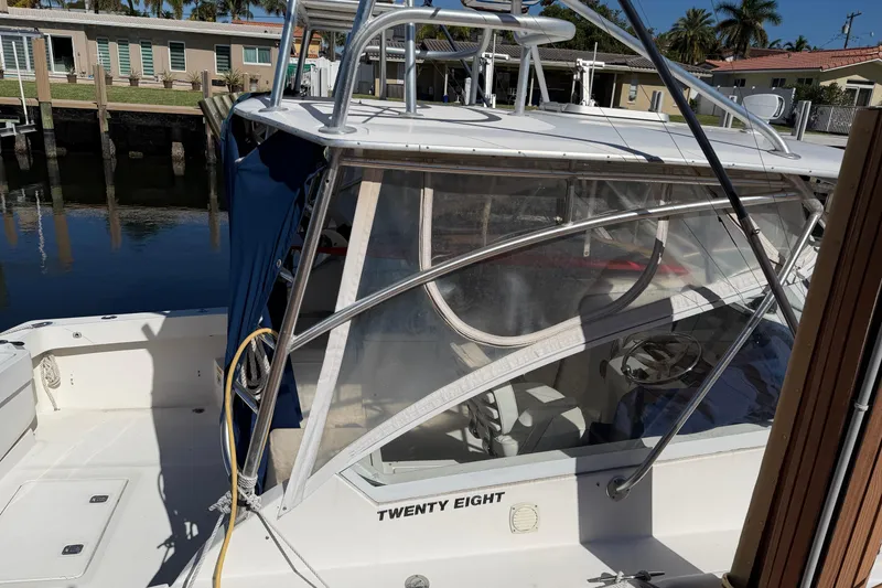 Slide: The Image of 2007 Luhrs 28 Open boat docked, featuring a sleek design and clear enclosure. - 11