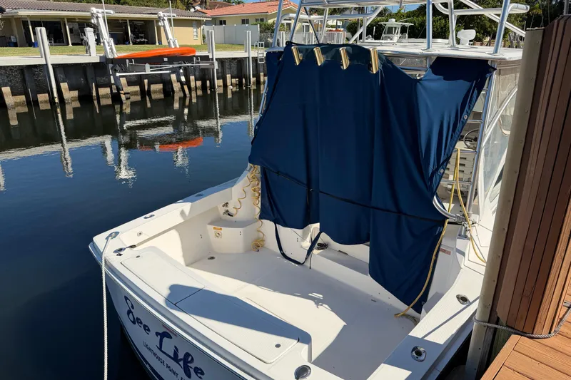 Slide: The Image of 2007 Luhrs 28 Open boat docked, featuring blue canvas cover and spacious deck area. - 13