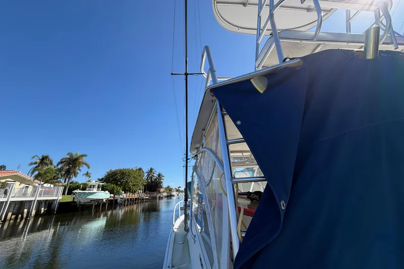 Slide: The Image of 2007 Luhrs 28 Open boat docked on a sunny canal with palm trees. - 15