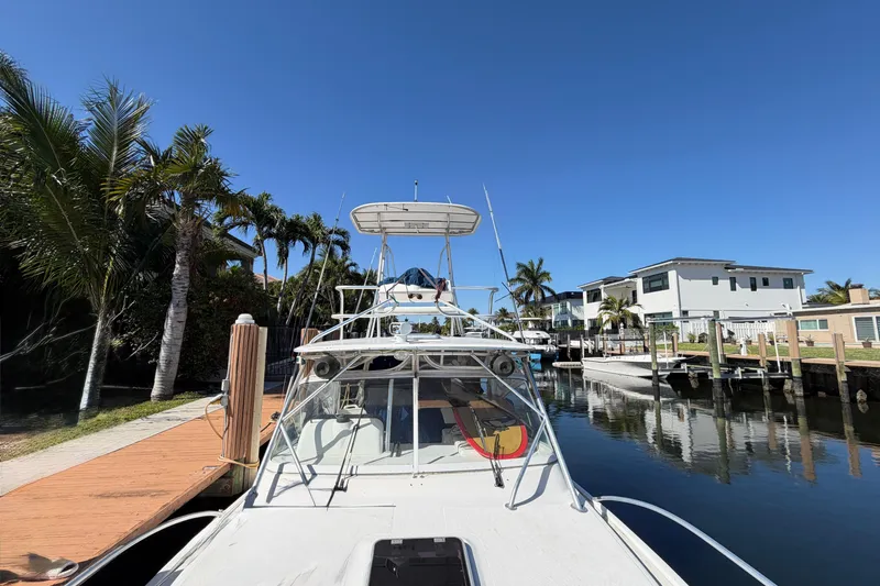 Slide: The Image of 2007 Luhrs 28 Open boat docked by palm trees and waterfront homes. - 23