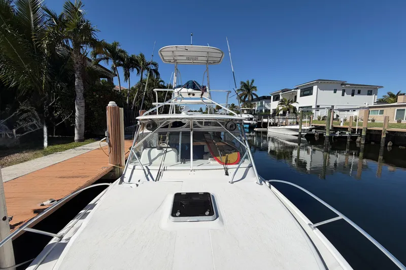 Slide: The Image of 2007 Luhrs 28 Open boat docked by palm trees and waterfront homes. - 24