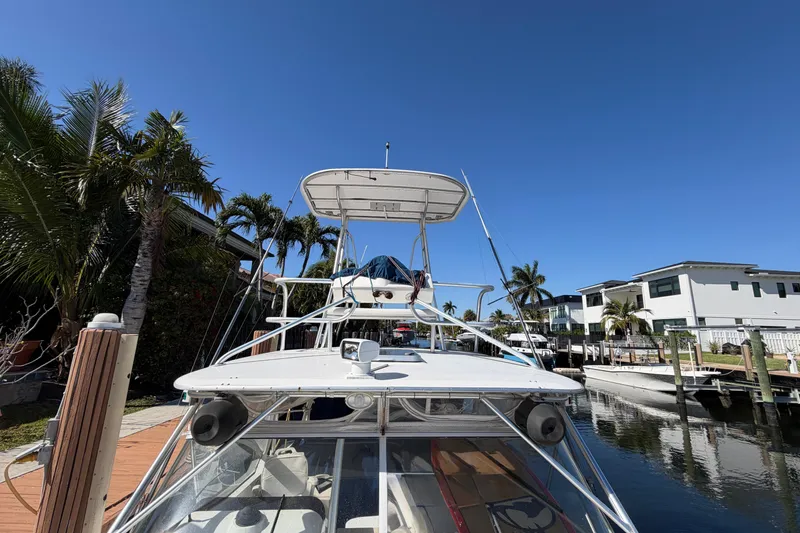 Slide: The Image of 2007 Luhrs 28 Open boat docked by palm trees and waterfront homes. - 26