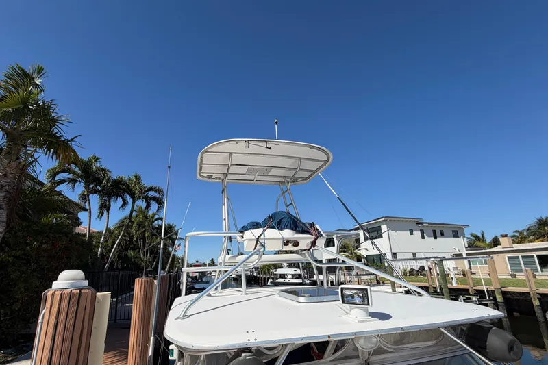 Slide: The Image of 2007 Luhrs 28 Open boat docked under clear blue sky, surrounded by palm trees. - 28