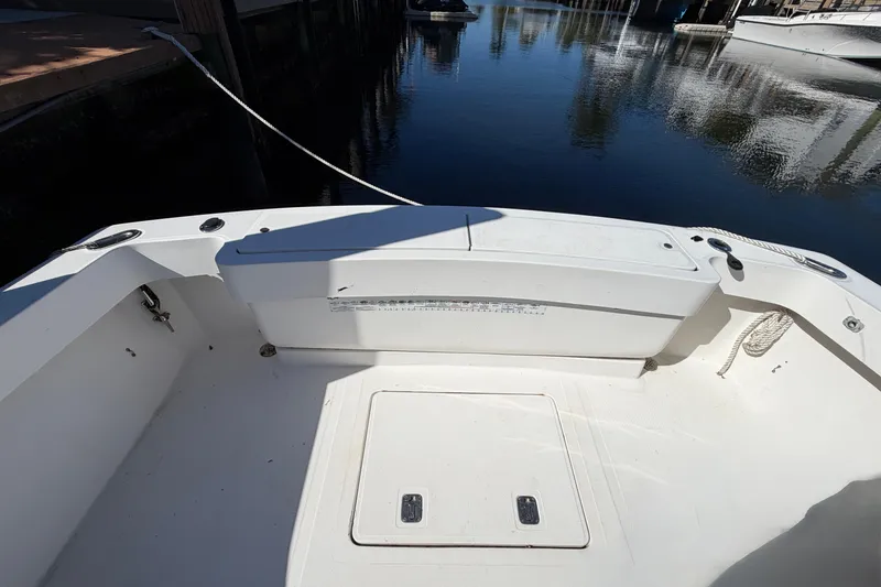 Slide: The Image of 2007 Luhrs 28 Open boat deck, featuring spacious seating and storage, docked by calm waters. - 33