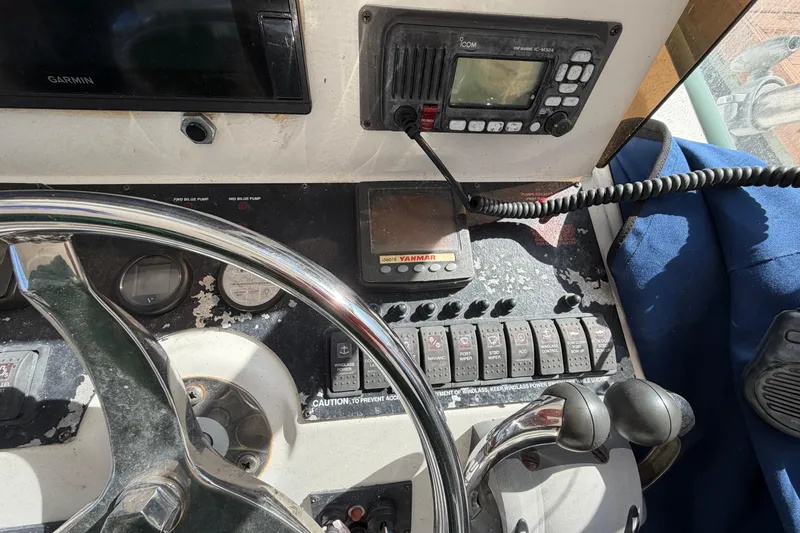 Slide: The Image of 2007 Luhrs 28 Open boat dashboard with steering wheel and navigation controls. - 59