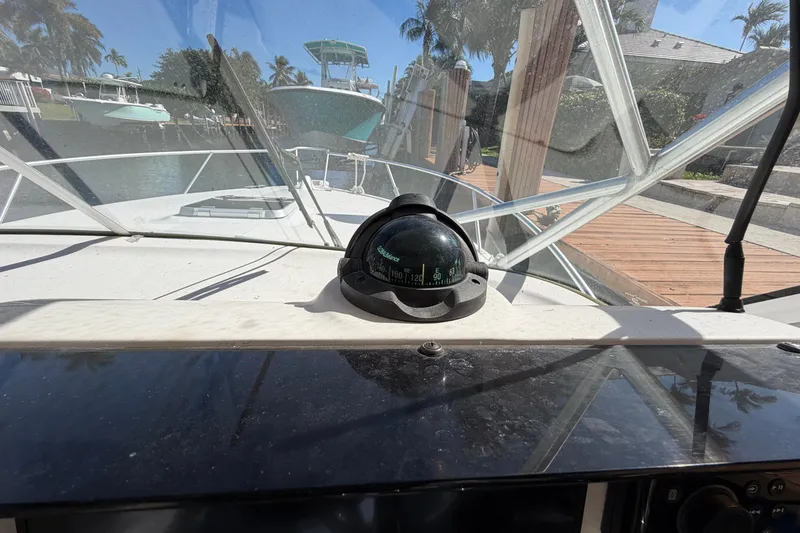 Slide: The Image of 2007 Luhrs 28 Open boat cockpit with compass, docked near waterfront homes. - 61