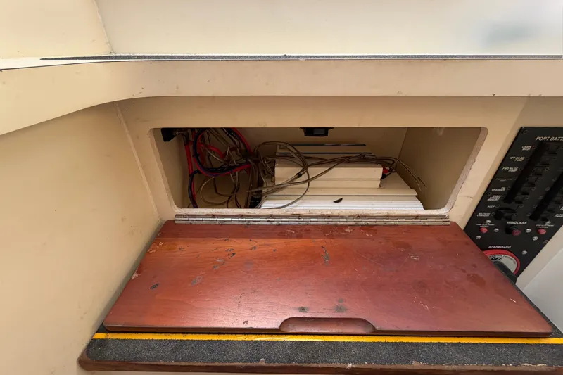Slide: The Image of 2007 Luhrs 28 Open boat interior wiring compartment with wooden cover and control panel. - 69
