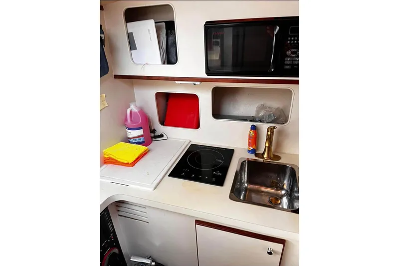 Slide: The Image of 2007 Lurhs Offshore Sport Fish boat kitchen with sink, stove, and microwave. - 73