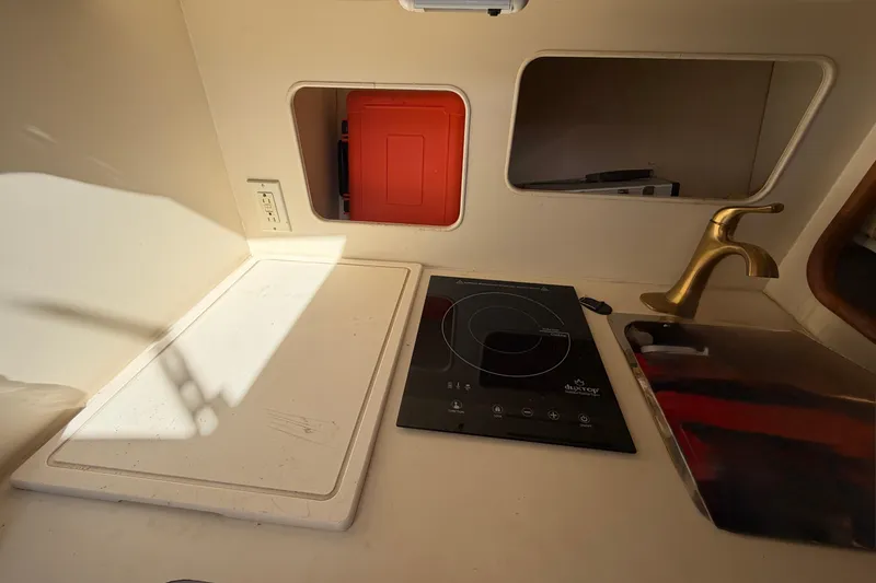 Slide: The Image of 2007 Luhrs 28 Open boat kitchen with stove, sink, and storage compartments. - 74