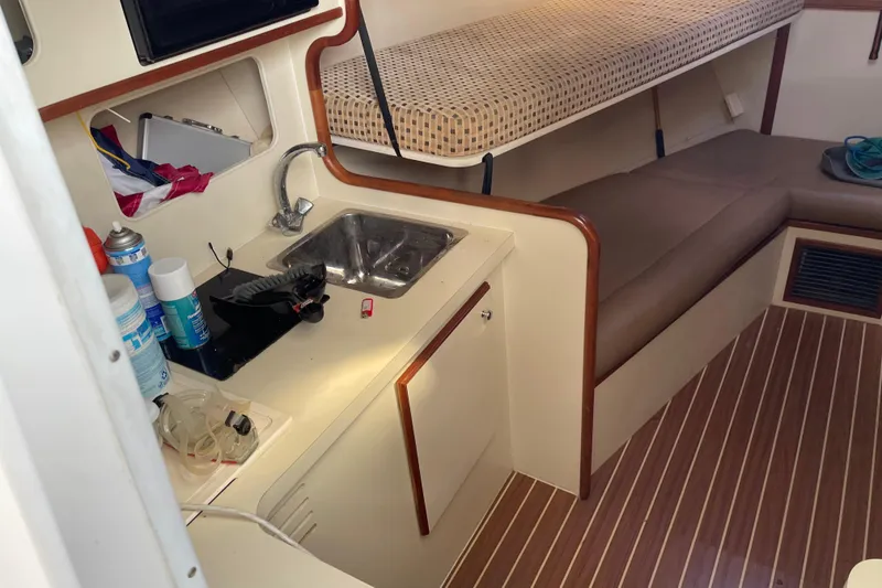 Slide: The Image of 2007 Luhrs 28 Open cabin interior with kitchenette, sink, and seating area. - 87