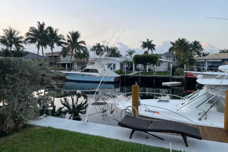 Slide: The Image of 2007 Luhrs 28 Open boat docked in a serene marina with palm trees. - 88