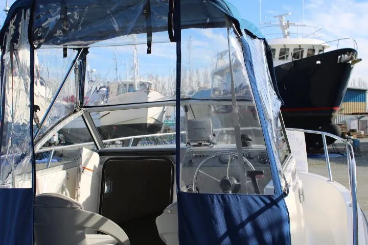 Slide: The Image of 2010 Trophy 1802 Walkaround boat with clear canopy, docked near other vessels. - 24