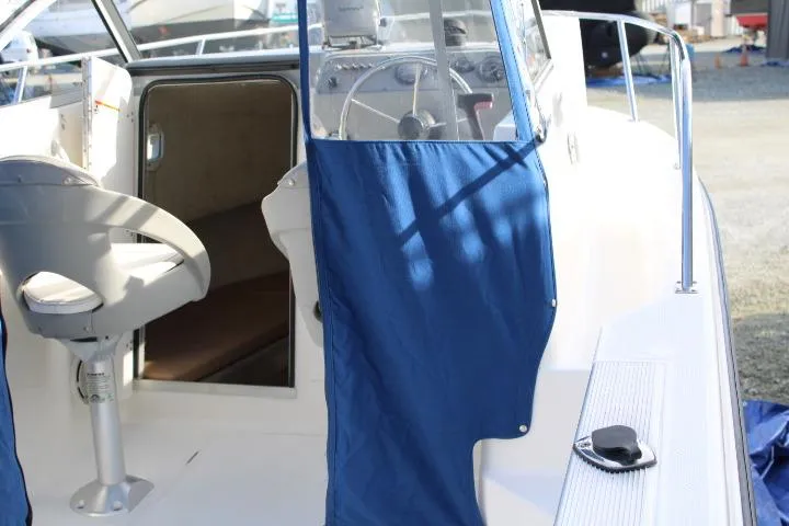 Slide: The Image of 2010 Trophy 1802 Walkaround boat interior with blue curtains and steering wheel. - 25