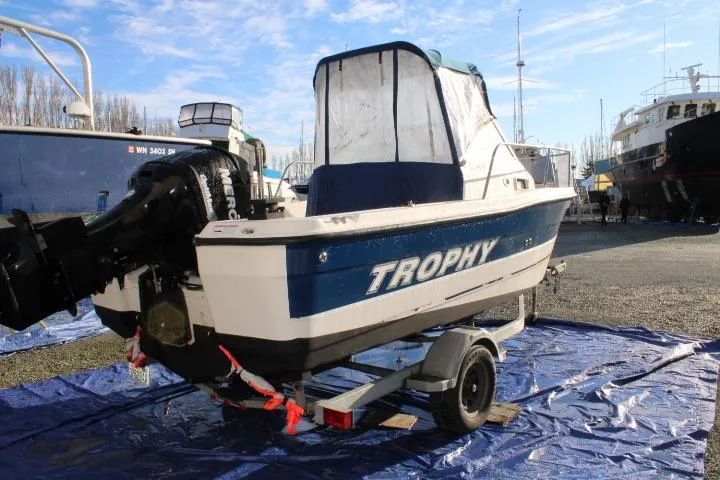 Slide: The Image of 2010 Trophy 1802 Walkaround boat on trailer, outdoor marina setting. - 3