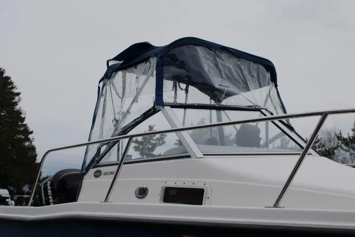 Slide: The Image of 2010 Trophy 1802 Walkaround boat with blue canopy and railing, side view. - 6