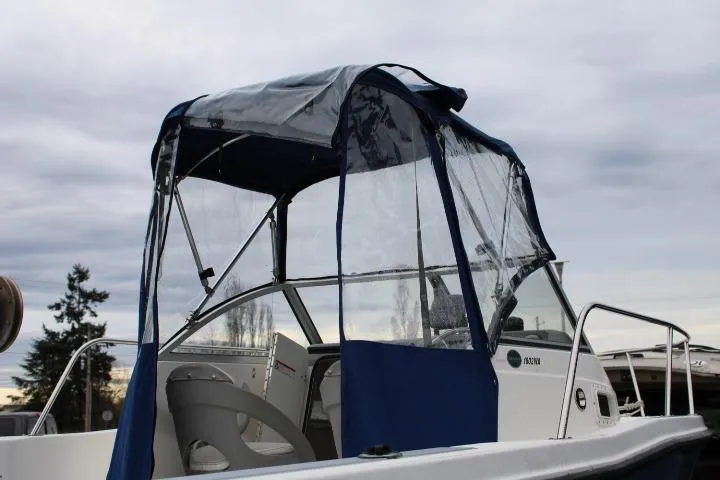 Slide: The Image of 2010 Trophy 1802 Walkaround boat with blue canopy and clear side panels. - 7