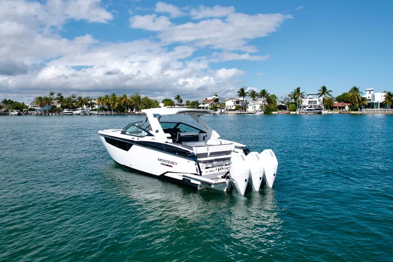 Slide: The Image of 2019 Monterey 385 Super Express boat on a sunny waterfront with palm trees. - 1