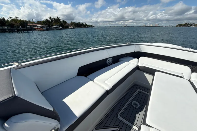 Slide: The Image of 2019 Monterey 385 Super Express boat interior with white seating, overlooking calm waters. - 19