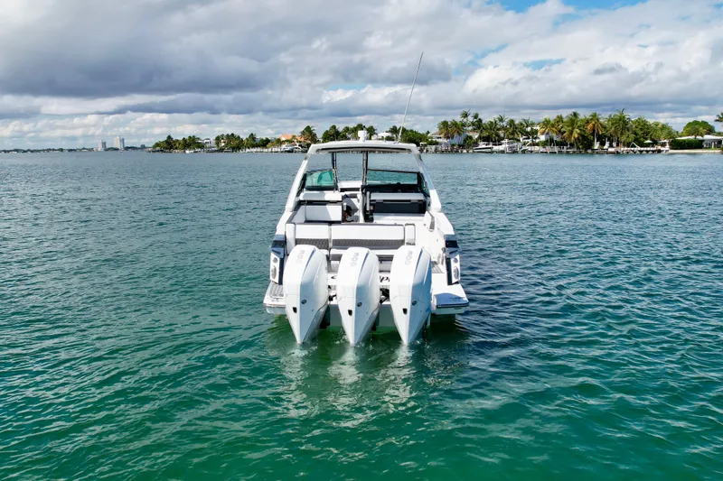 Slide: The Image of 2019 Monterey 385 Super Express boat on calm water, tropical backdrop. - 2
