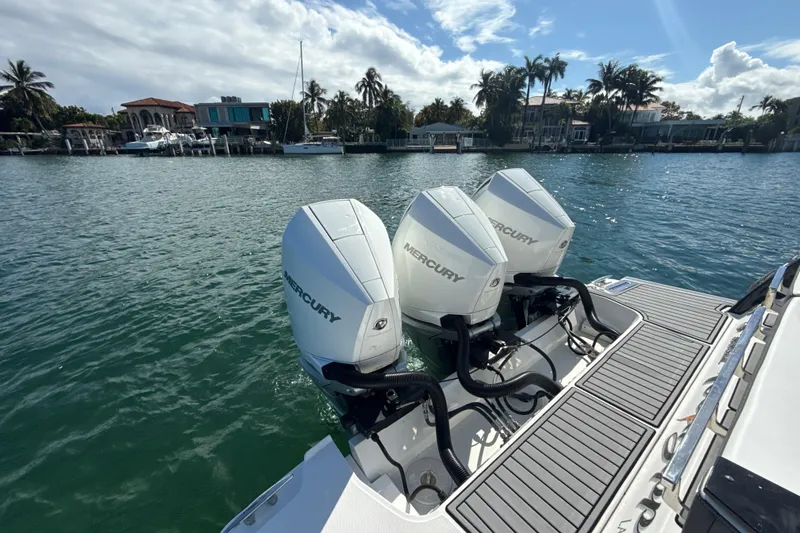 Slide: The Image of 2019 Monterey 385 Super Express with triple Mercury outboard engines on a sunny waterfront. - 6