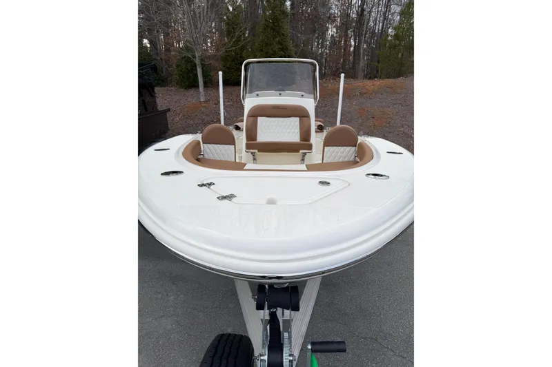 Slide: The Image of 2026 Pioneer 180 Islander boat with tan seating, parked on a trailer. - 2