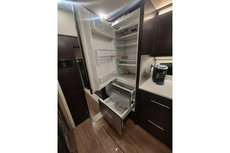 Slide: The Image of 2016 Regal 53 Sport Coupe kitchen with open refrigerator and modern cabinetry. - 22