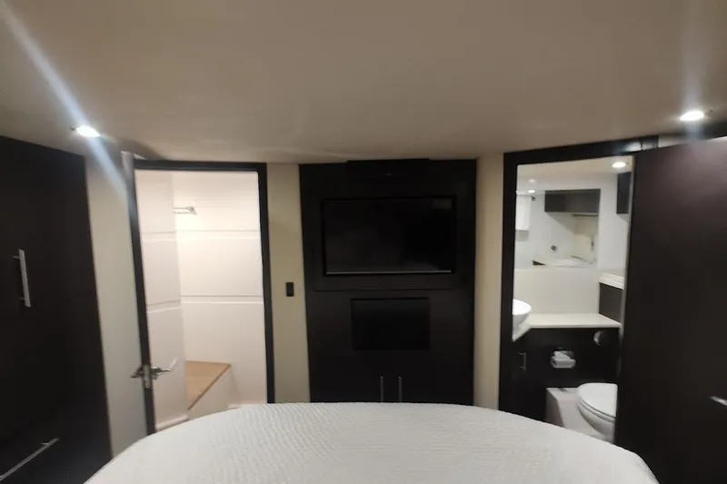 Slide: The Image of Interior of 2016 Regal 53 Sport Coupe yacht, featuring modern bedroom and bathroom. - 25